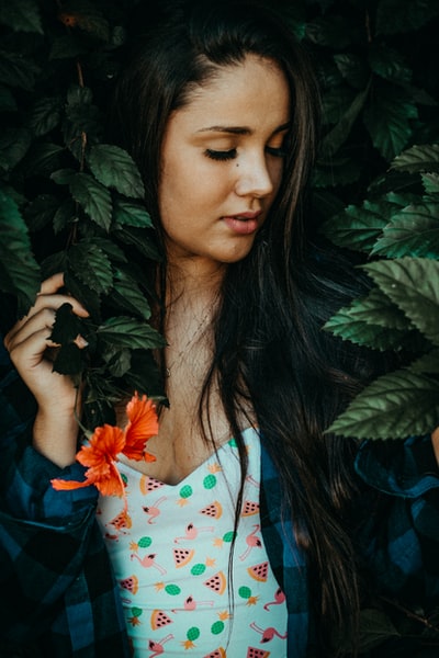 女人拿着绿色的有叶子的植物
